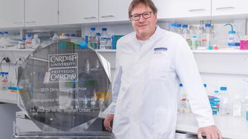 Merged image of Prof. Stephan Urban in the lab and the Chris McGuigan Prize trophy is added to the left of the picture. Prof. Stephan Urban in the laboratory; the Chris McGuigan Prize trophy is added to the left of the picture.